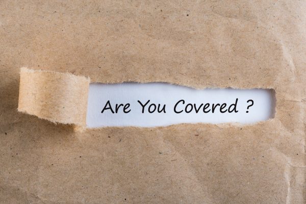 Are,you,covered?,question,message,appearing,behind,ripped,brown,paper.